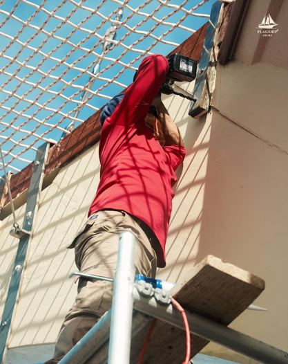 A crew member working on deck rigging during restoration